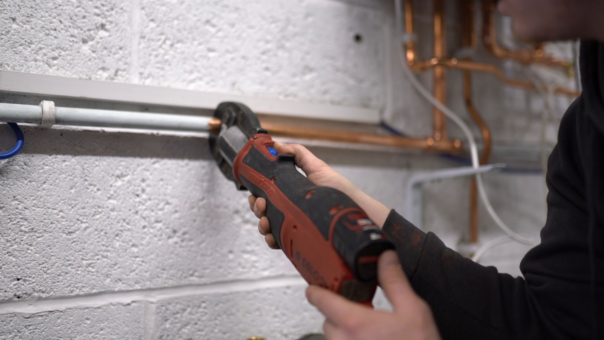 Engineer pressing copper pipework into place